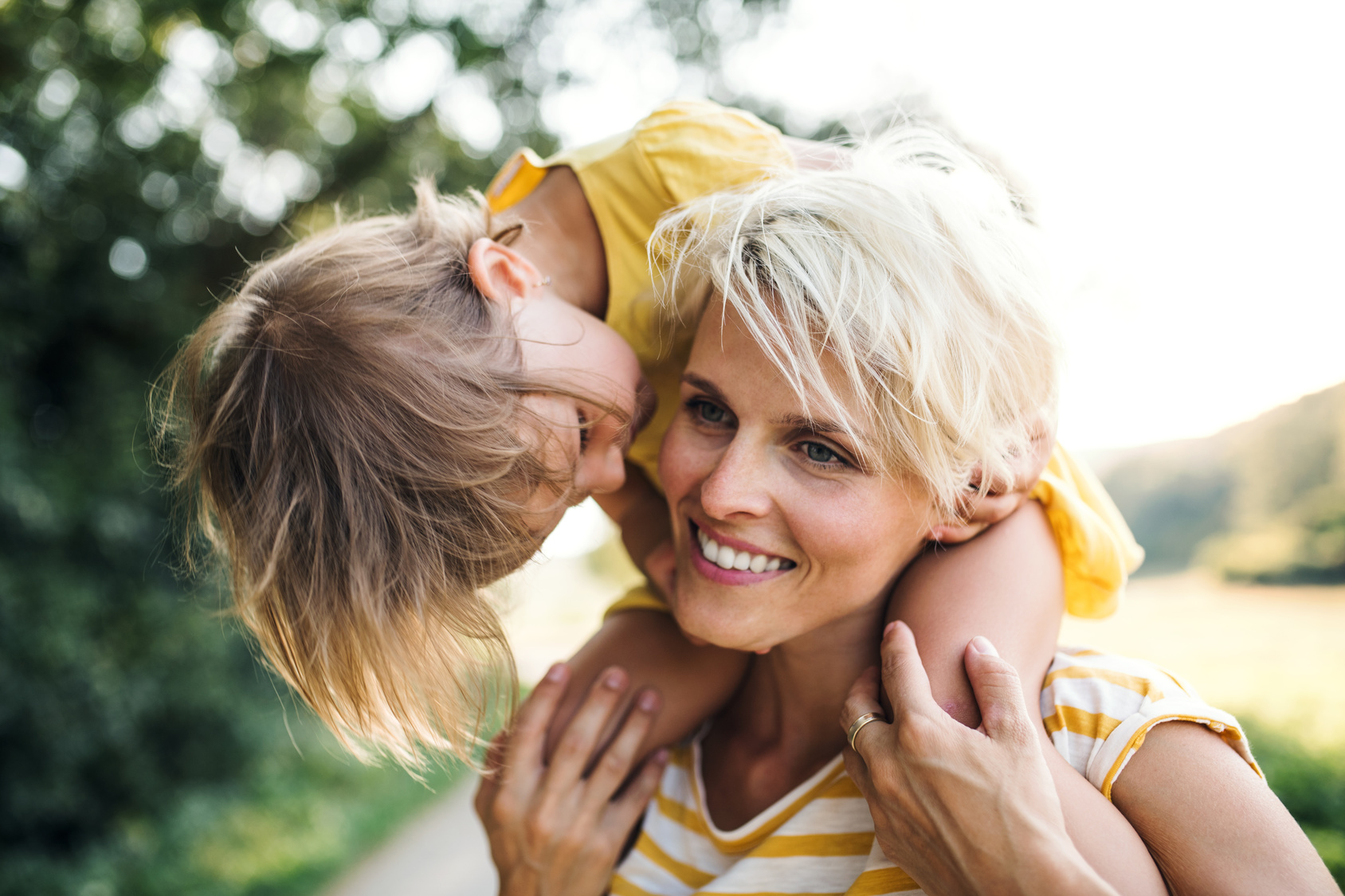 Mutter trägt Kind auf Schultern. Umgangsrecht und Sorgerecht im Familienrecht. Beratung bei Trennung und Scheidung.
